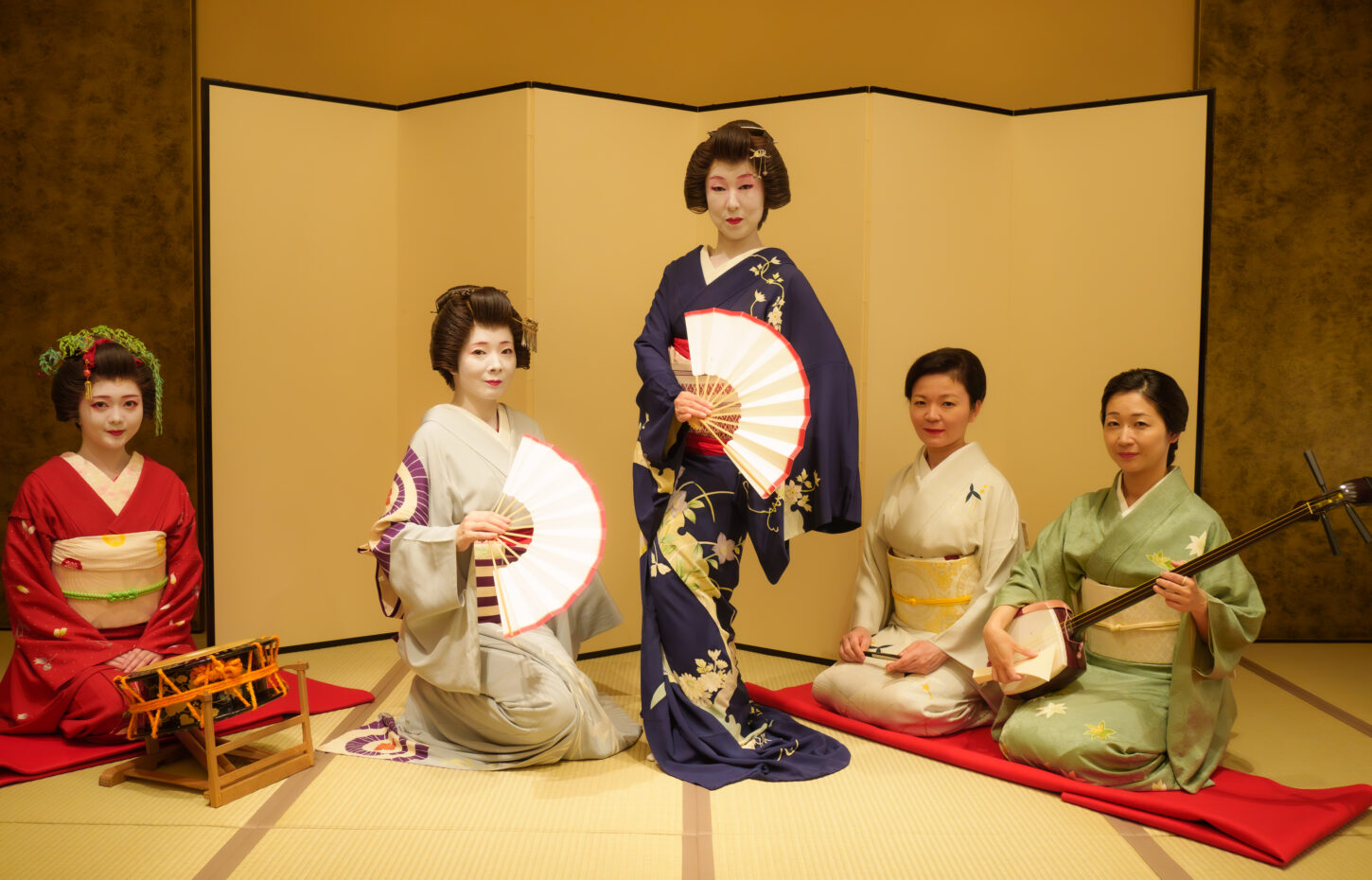Geisha performing traditional dance with shamisen in a private tatami room in Tokyo