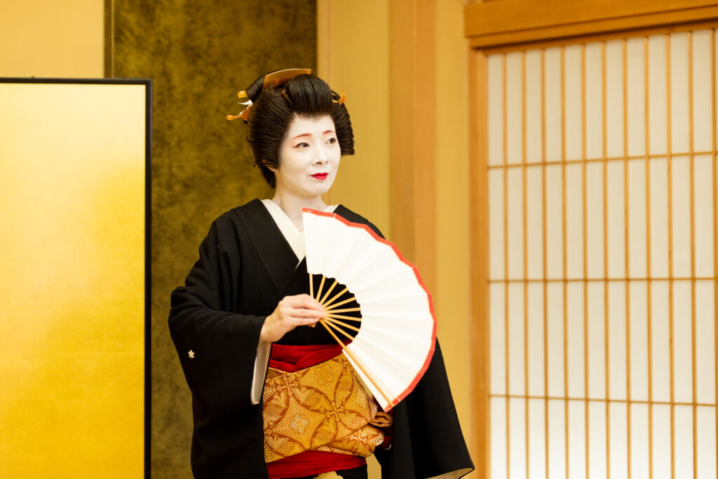 都鳥のお座敷茶屋で黒紋付を着た芸者衆が伝統舞踊を披露する場面