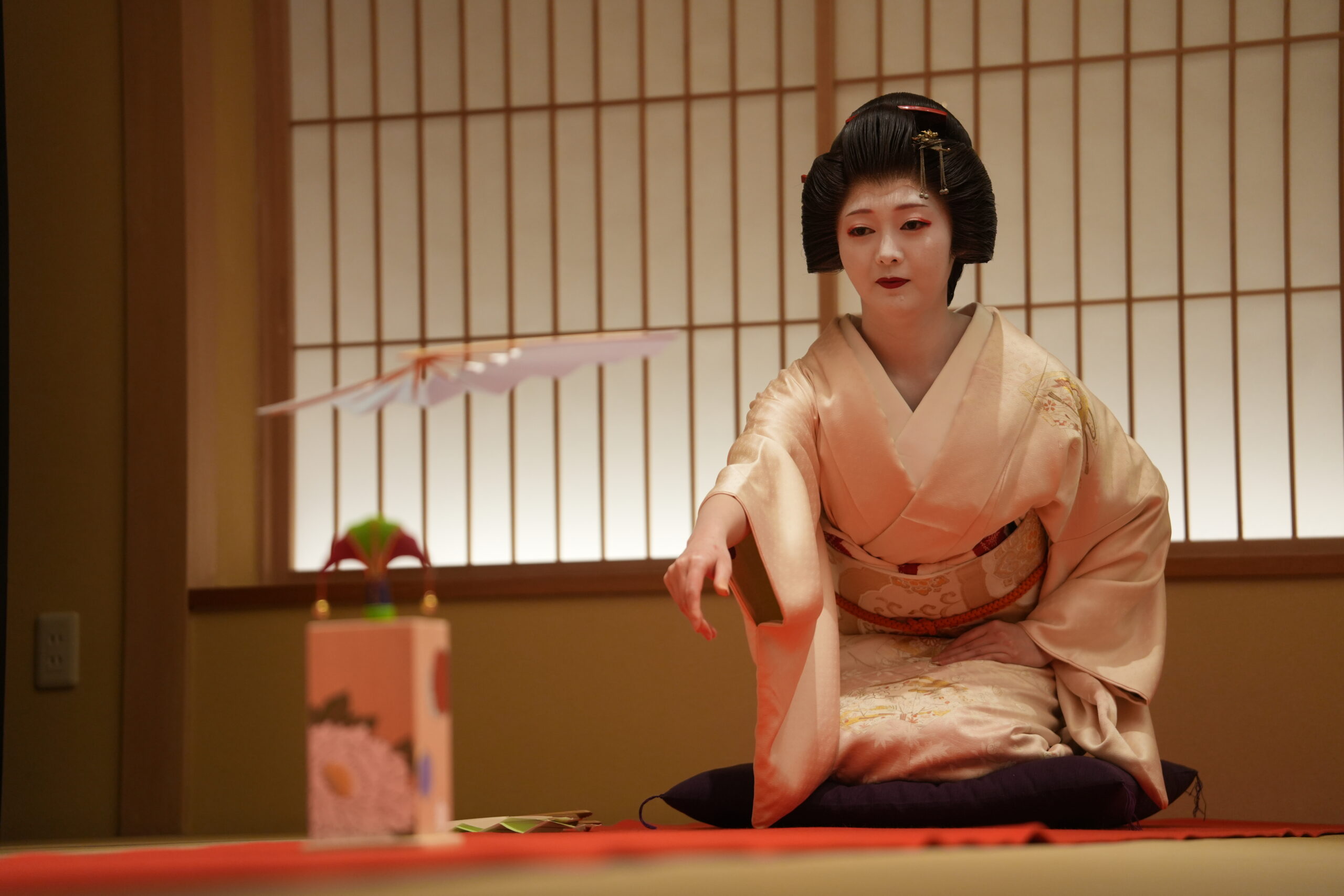 Geisha performing traditional dance and shamisen music at an ozashiki banquet