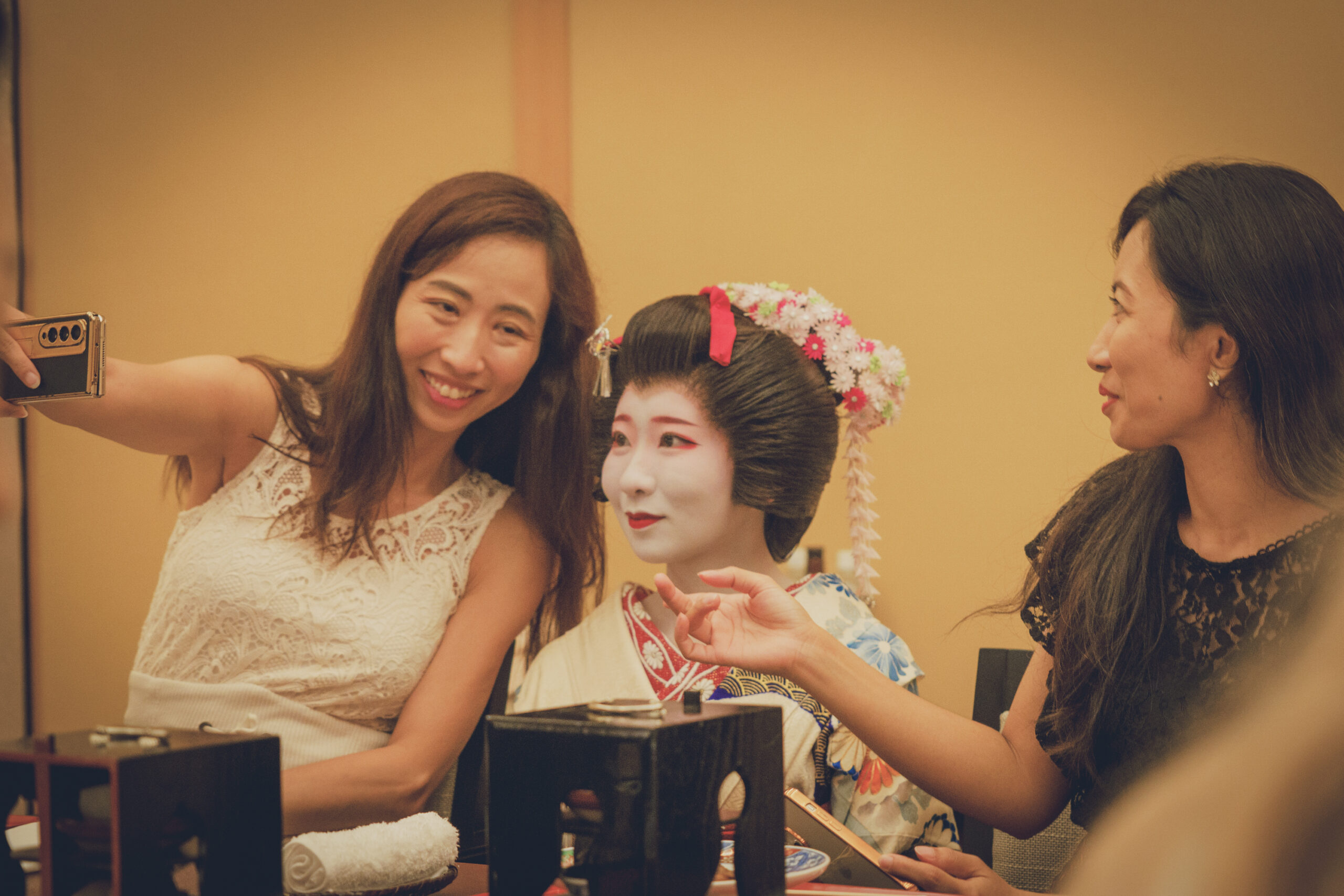 Guest taking a photo with geisha after an ozashiki banquet at Asakusa Miyakodori Tokyo