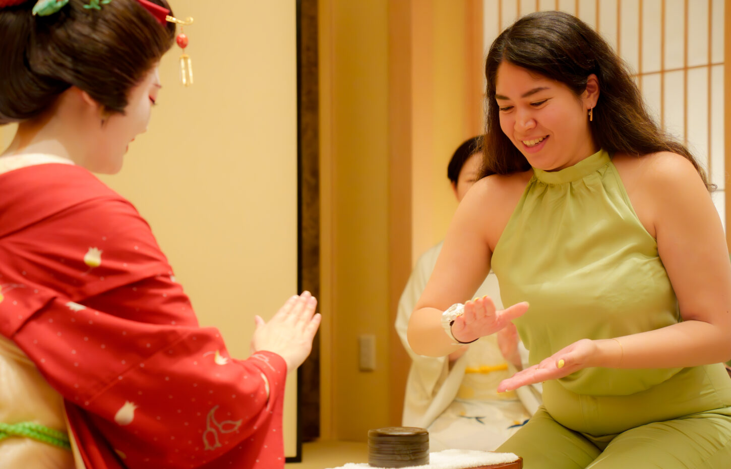 Geisha and guest playing Konpira Fune Fune cup game at an ozashiki banquet in Asakusa