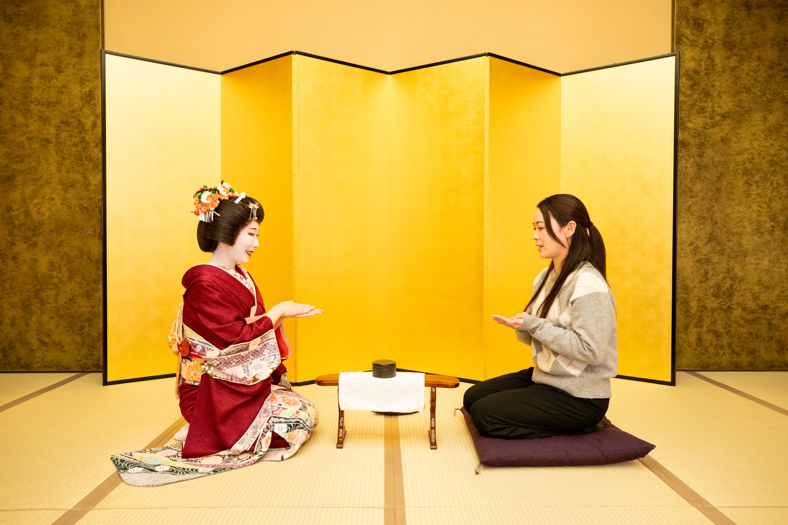 The physical setup of Konpira Fune Fune: kyōsoku armrest stand with the hakama placed on top, between two players