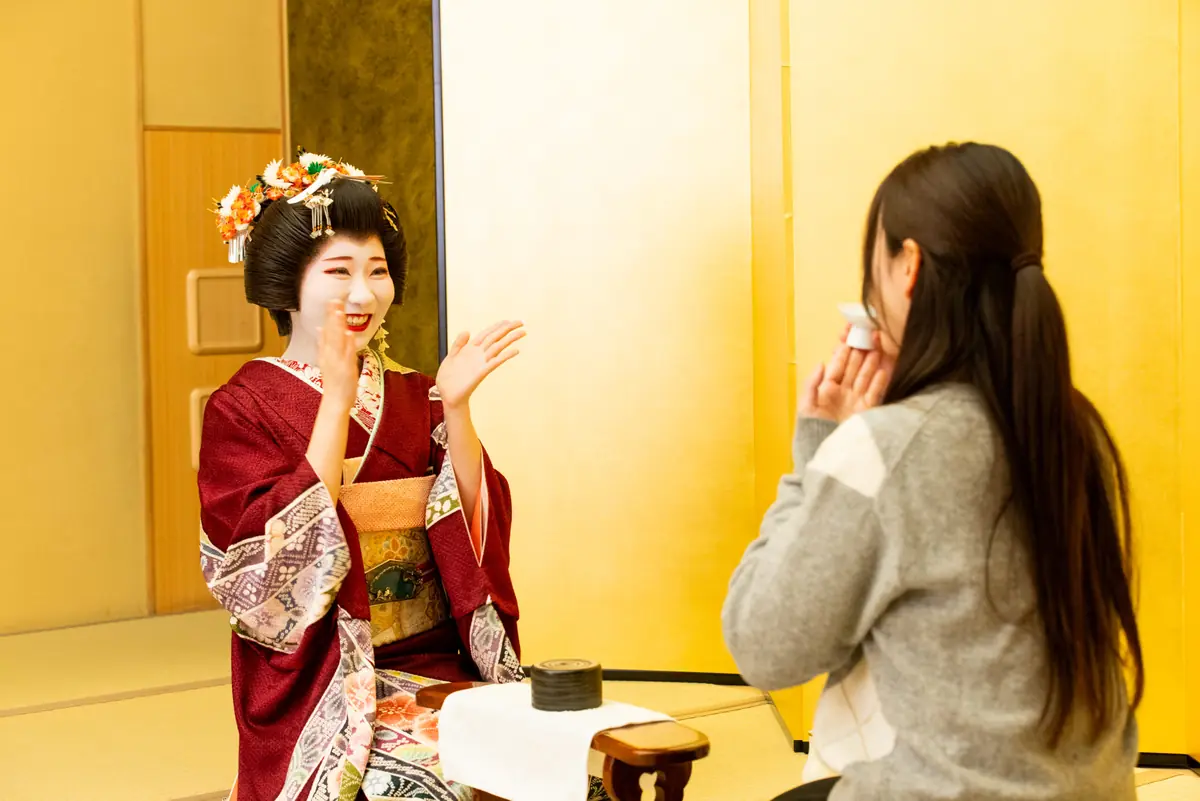 geisha and guests playing traditional ozashiki asobi games at banquet