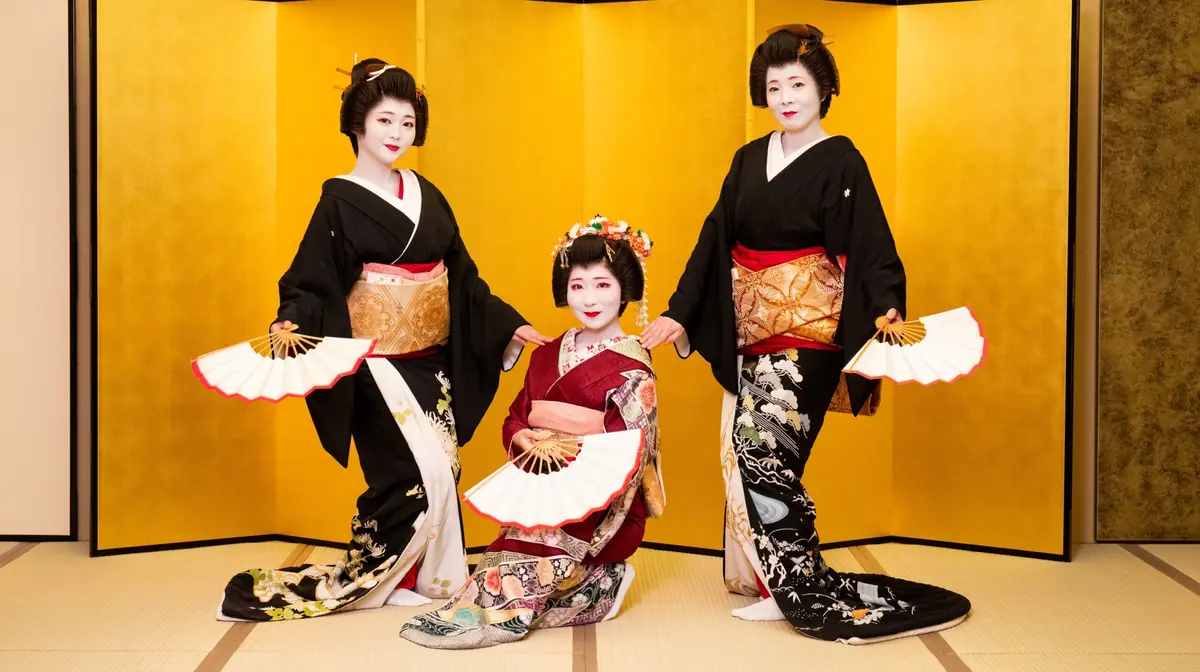 Three Asakusa geisha performing a fan dance before a gold screen at Miyakodori