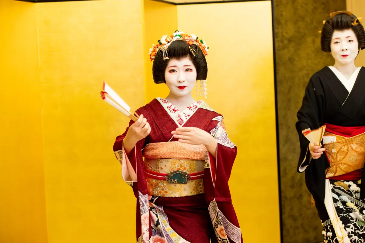 Hangyoku apprentice geisha in vibrant red kimono performing classical Japanese dance at Asakusa Miyakodori