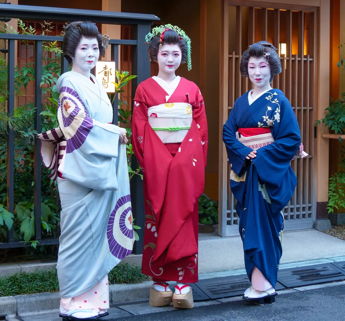 The red embroidered collar of a maiko (left) compared to the solid white collar of a geisha (right) — the clearest visual difference