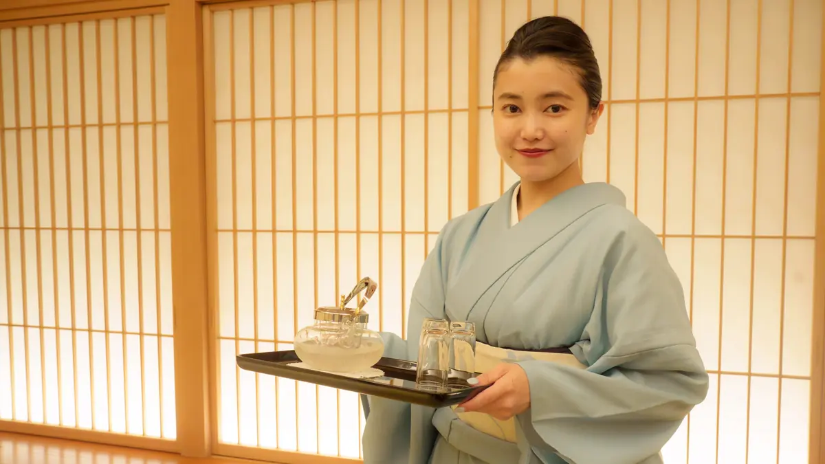 Japanese omotenashi hospitality — server pouring tea with graceful care