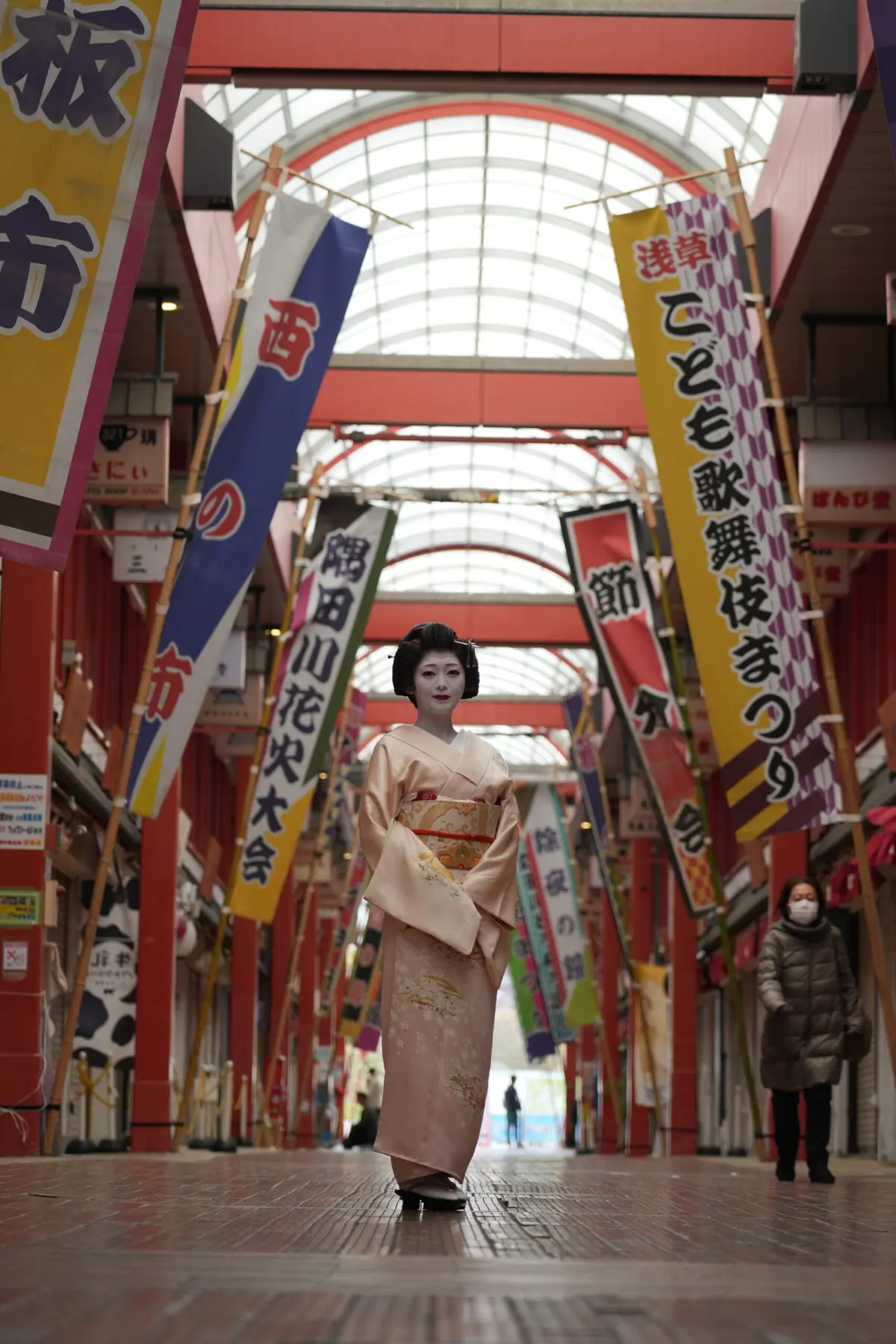 Close-up of Asakusa geisha in traditional white face makeup and kimono with elaborate hair ornaments