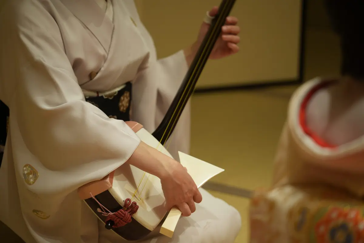 Geisha playing shamisen during a traditional ozashiki performance in Asakusa Tokyo