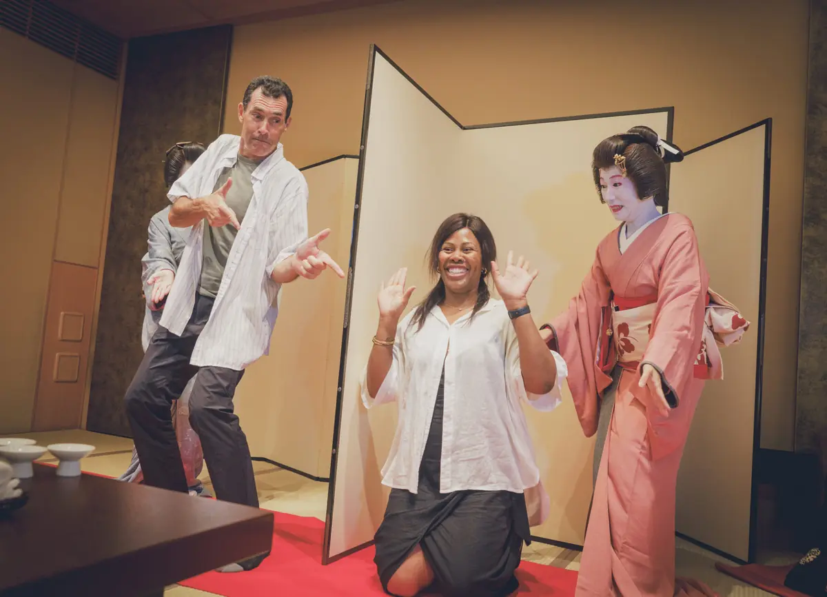 Two or three geisha with guests enjoying music and play in a private tatami room