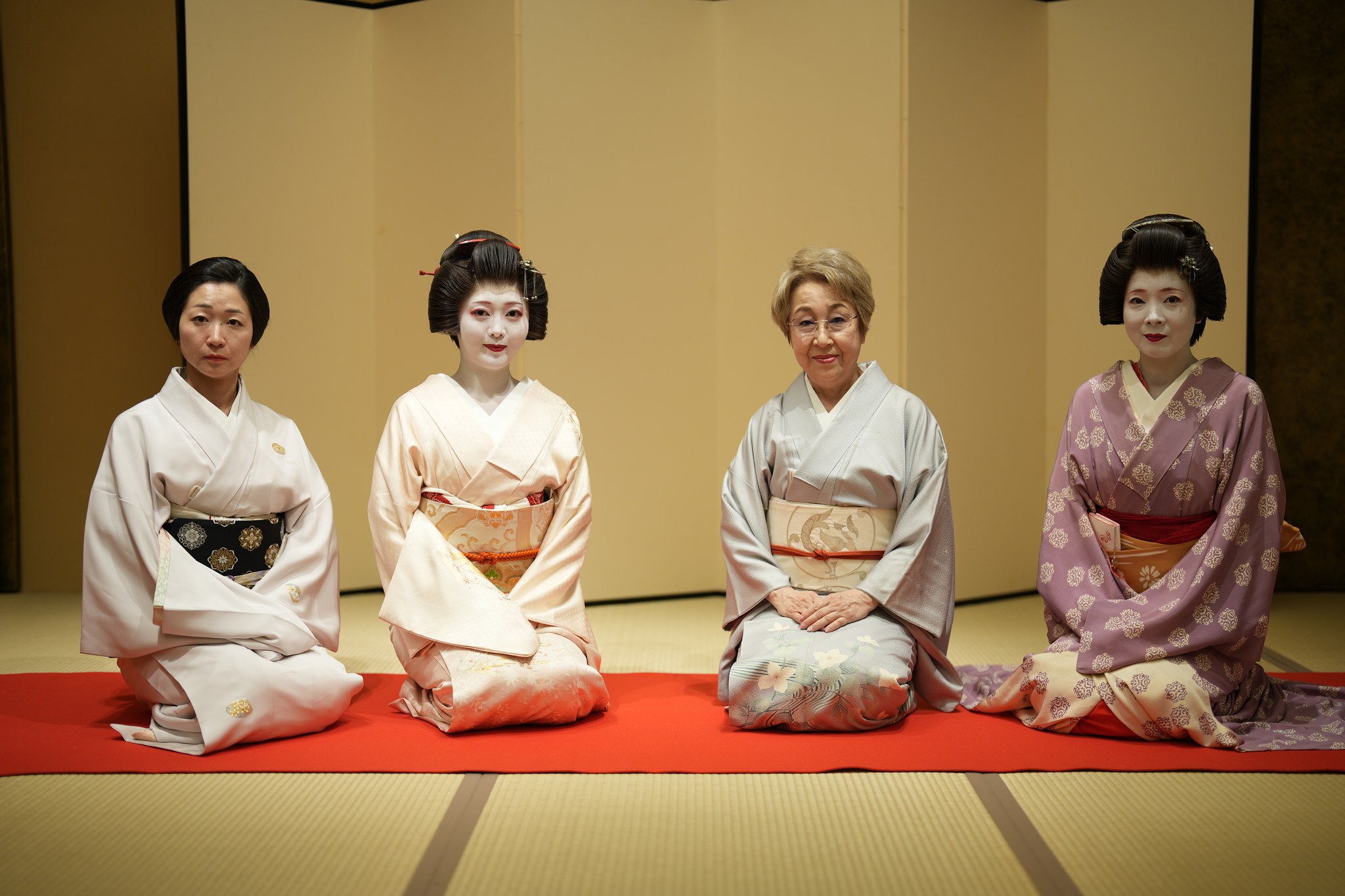 Three Asakusa geisha with the okami in formal kimono