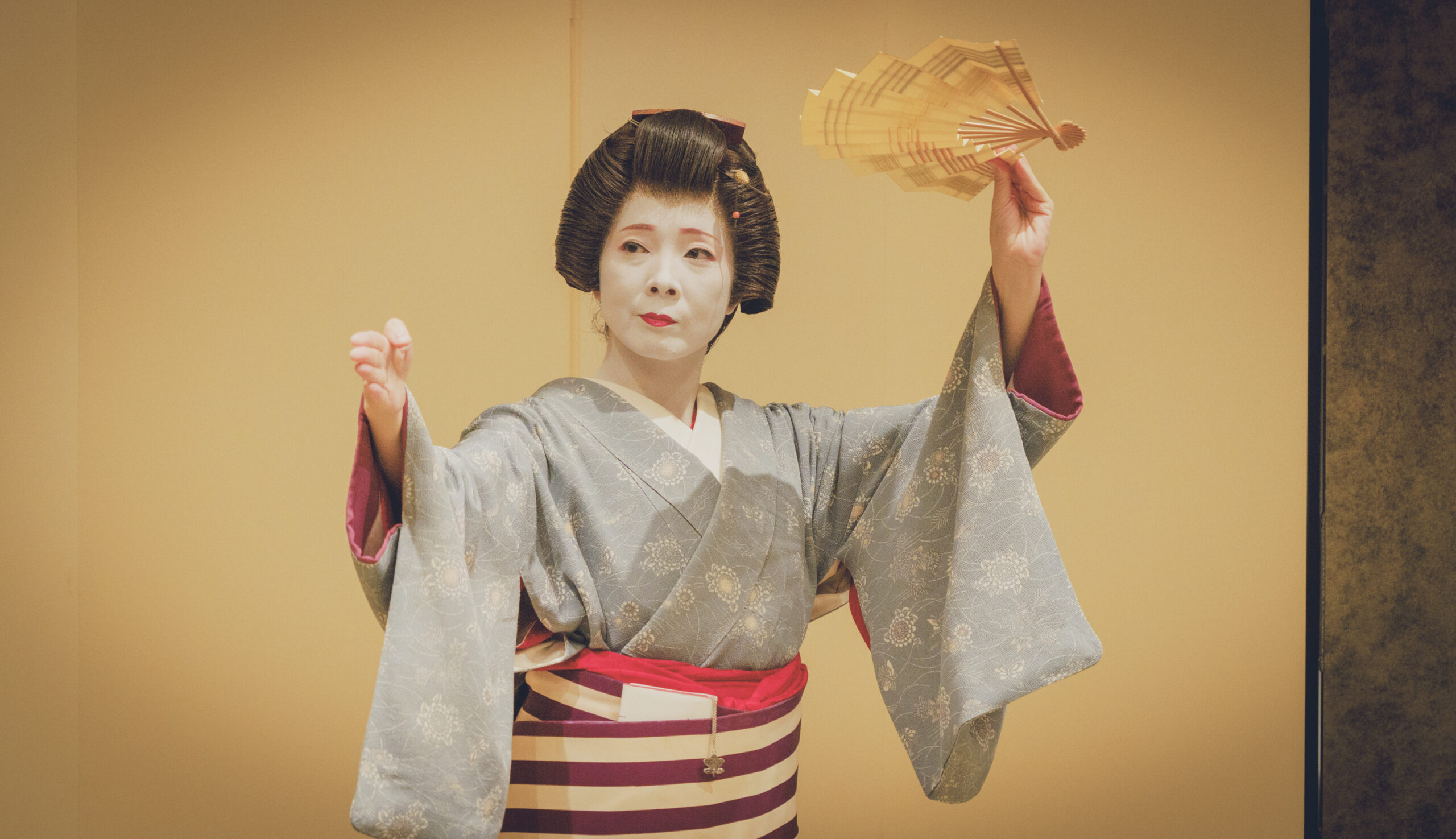 An Asakusa geisha performing a traditional fan dance at an ozashiki — the gei (art) that defines what a geisha is