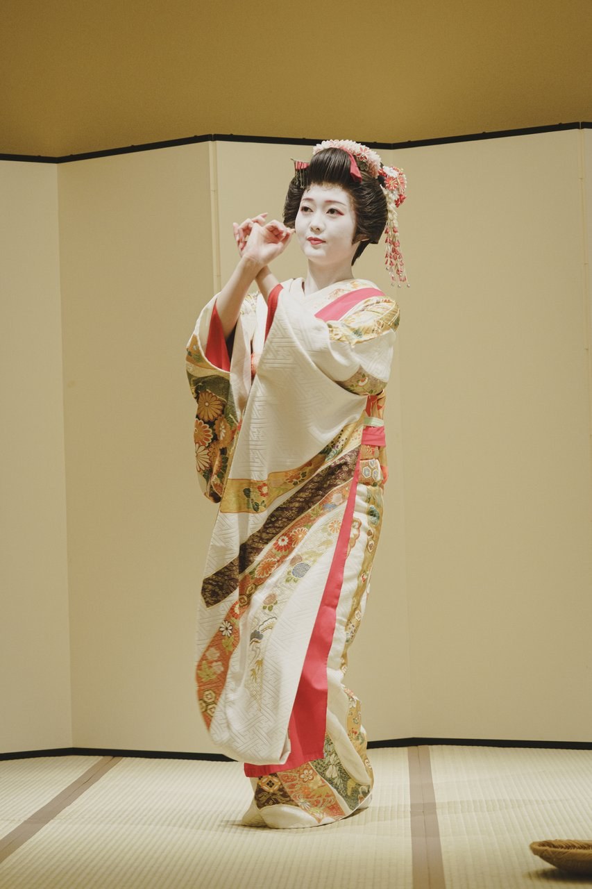An Asakusa geisha performing a traditional dance in full kimono at an evening ozashiki banquet at Miyakodori — the experience that draws guests from around the world