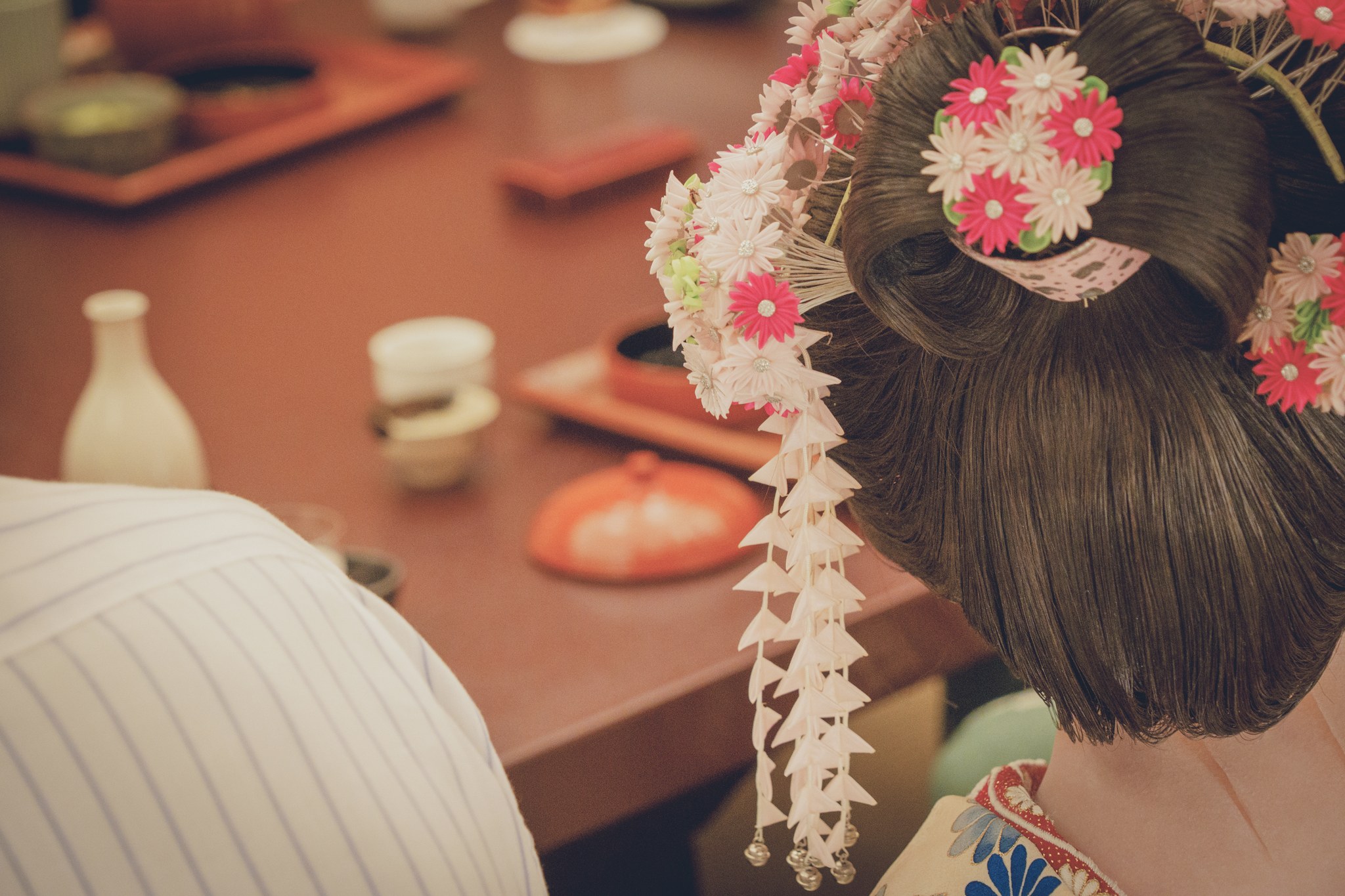 Close-up of a geisha's kanzashi hair ornaments with floral motifs and silver bira