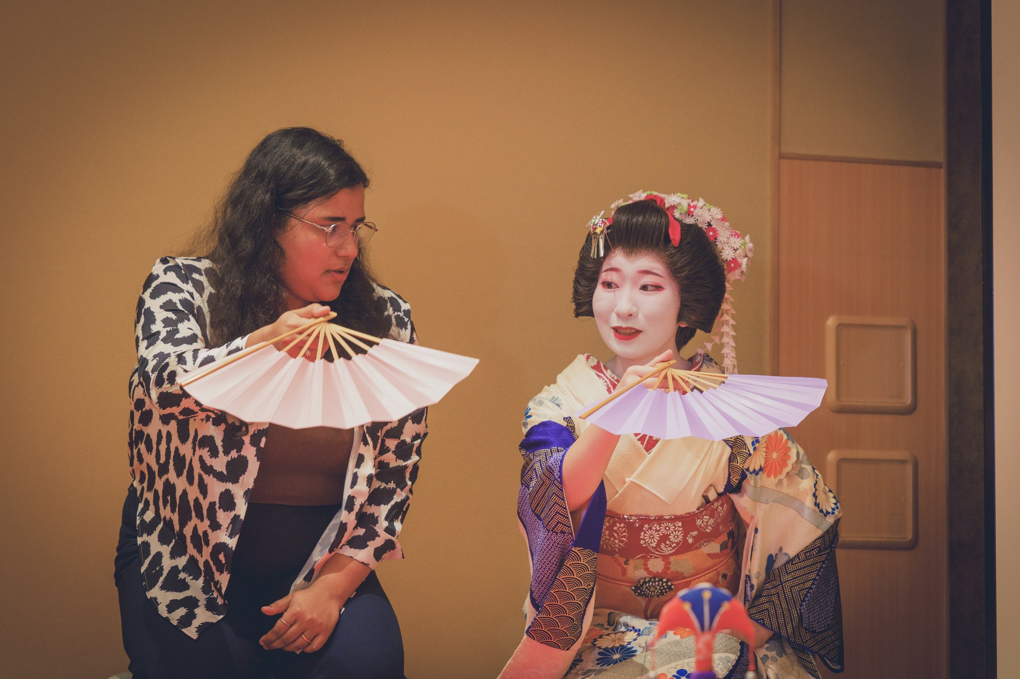 A geisha and an overseas guest playing the fan-throwing game tosenkyo