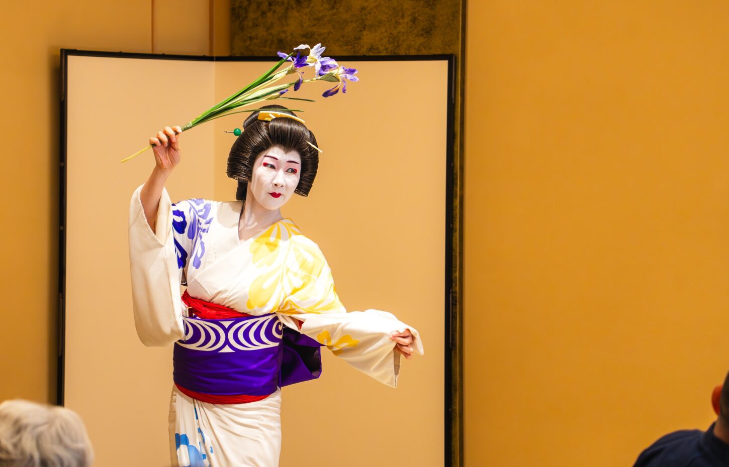 An Asakusa geisha in a white-and-gold kimono performing a dance at Miyakodori in Asakusa, Tokyo