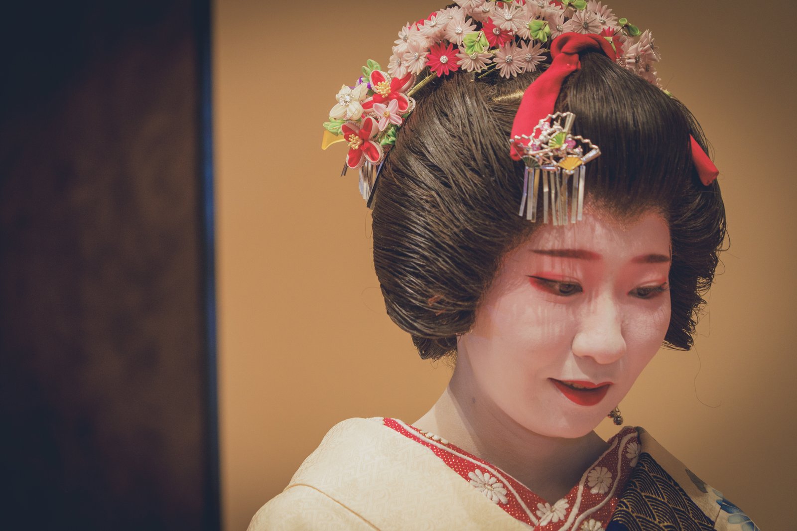 A geisha's white makeup applied in the traditional style, seen up close