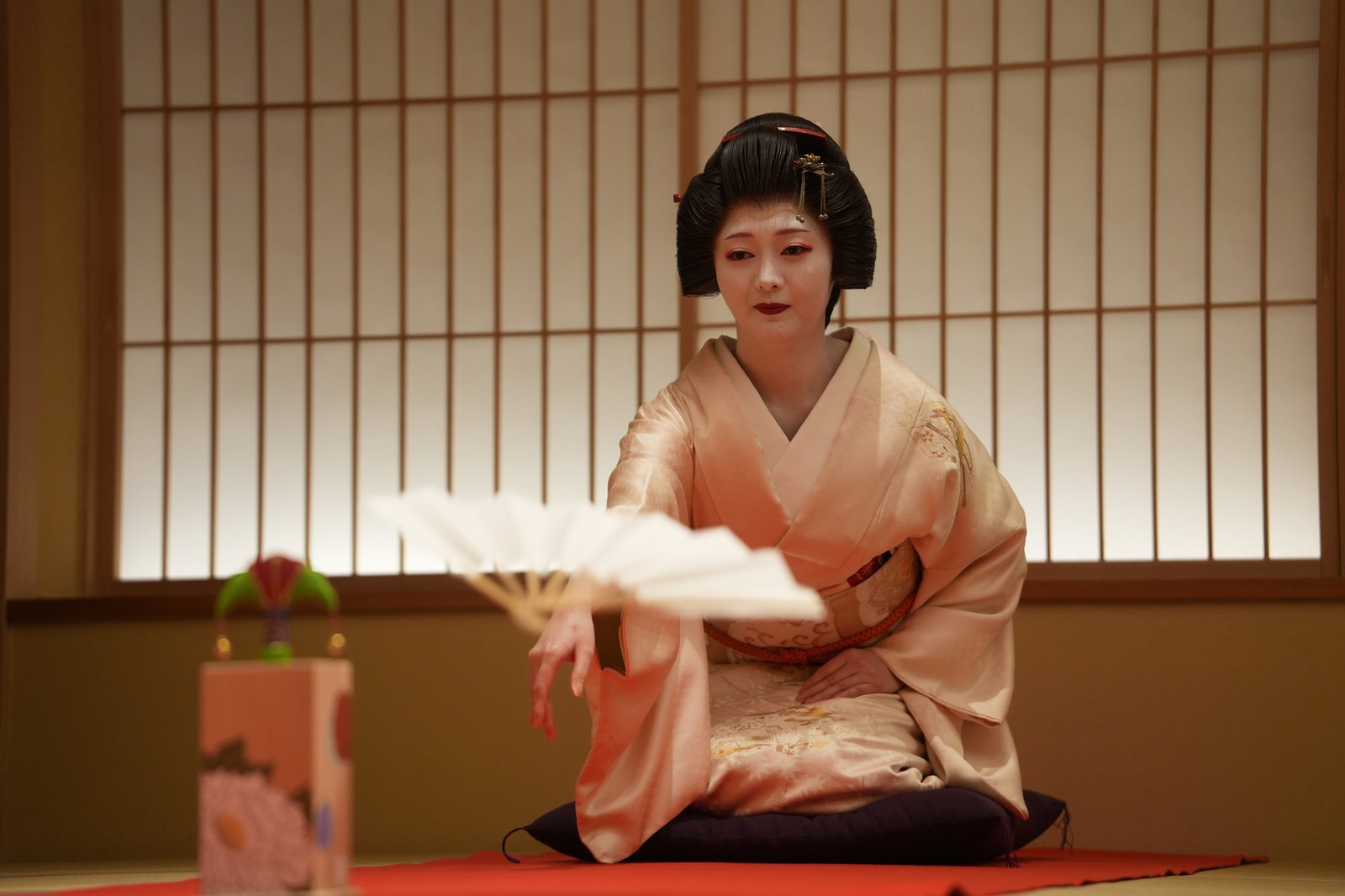 An Asakusa geisha tossing a fan at the butterfly target in Tōsenkyō, one of the ozashiki games