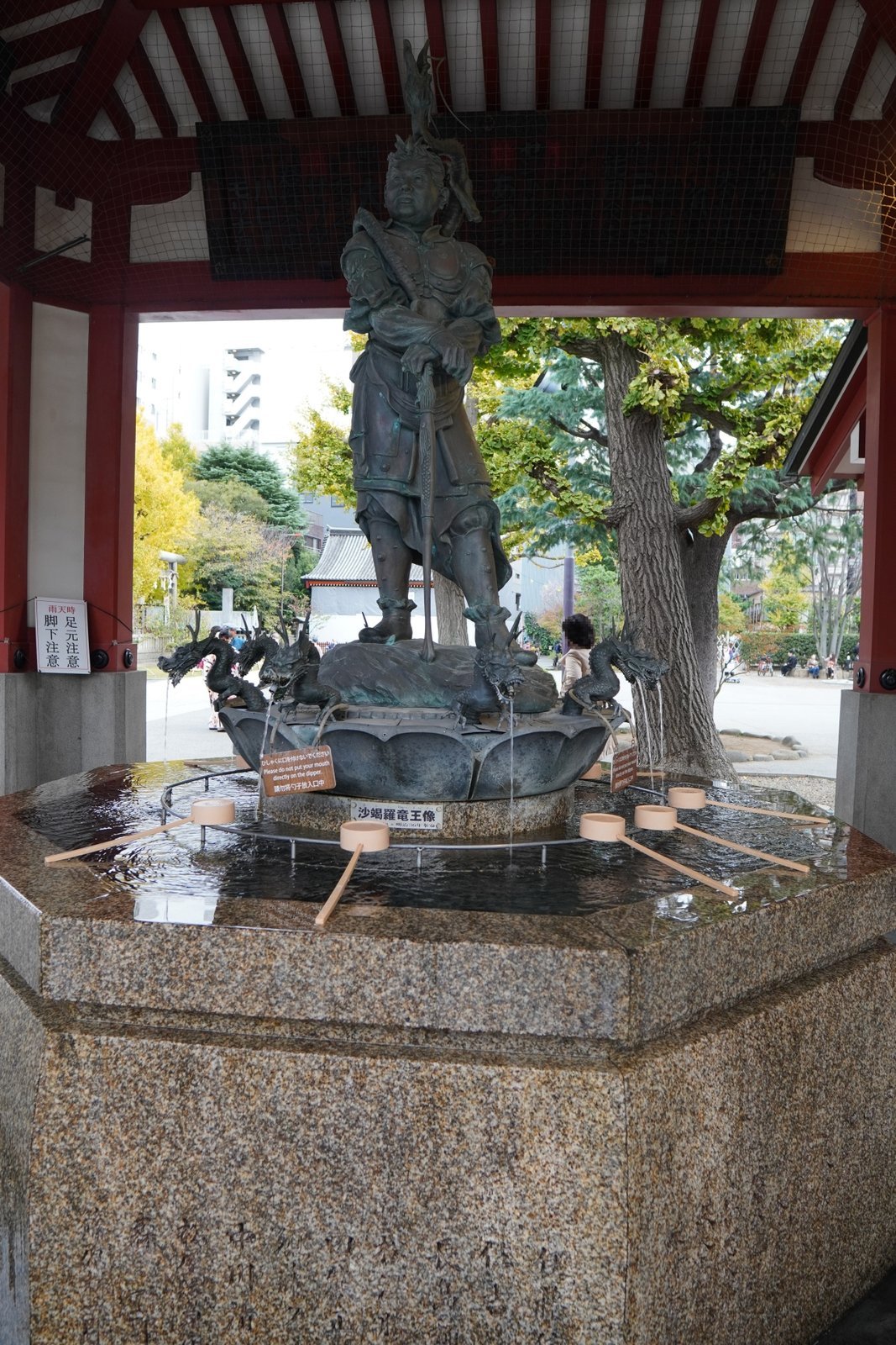 The dragon fountain at Senso-ji's temizuya against ginkgo trees just starting to turn, in the quiet hours