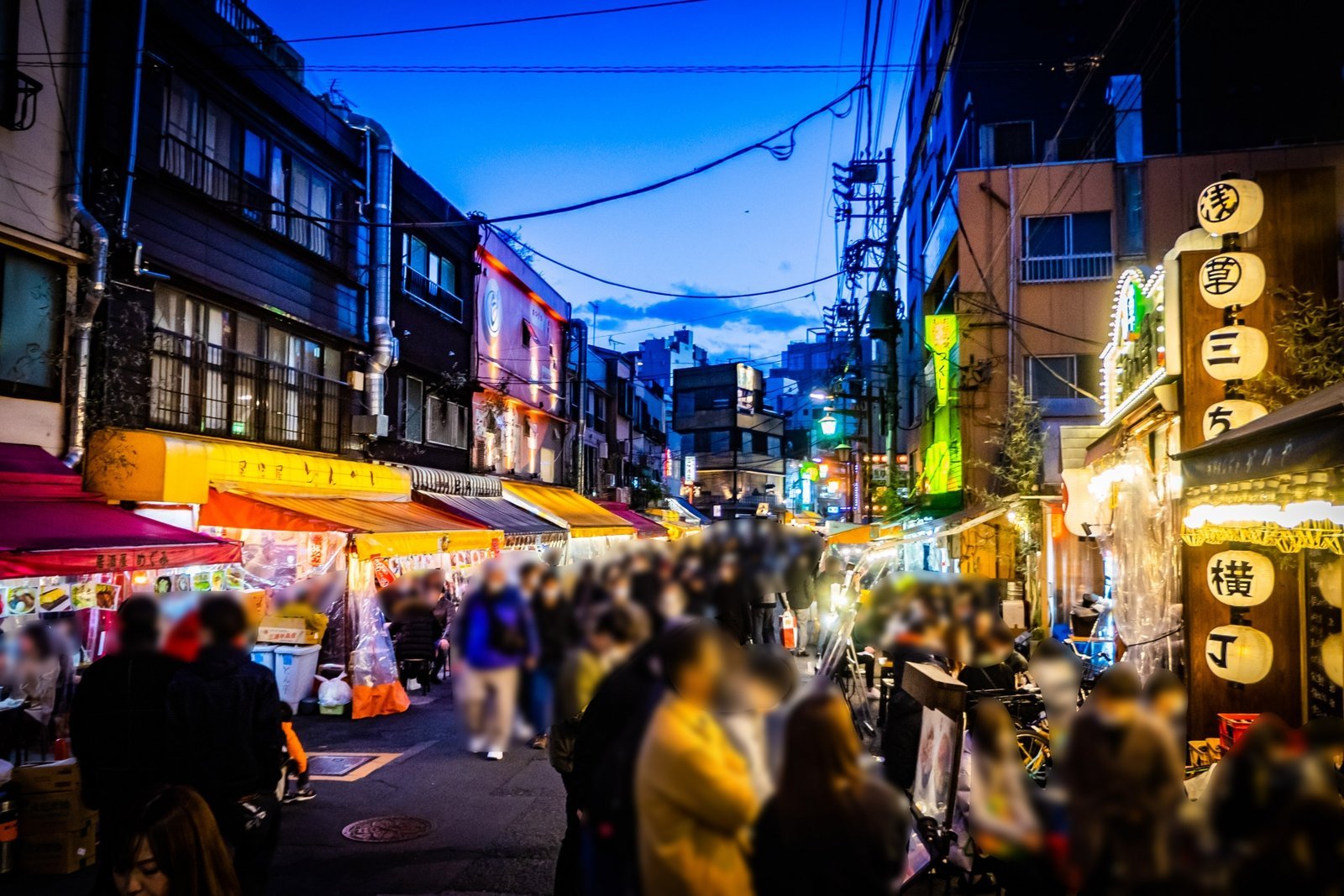 Hoppy Street in Asakusa at night, a row of old-fashioned izakaya lit by lanterns with people out on the street