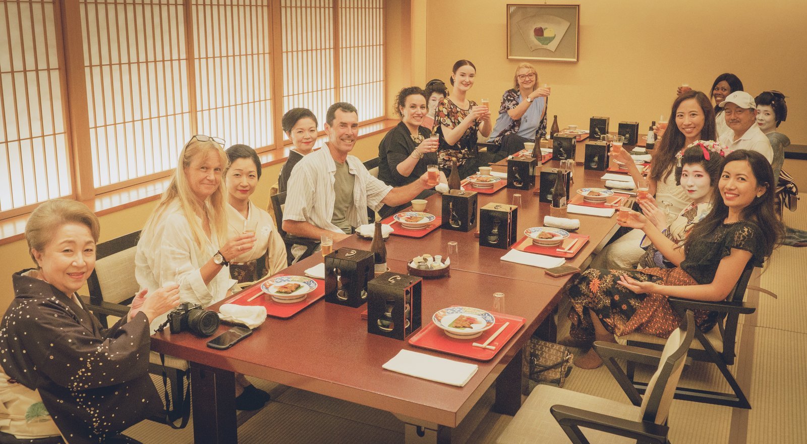 International guests raising a toast with Asakusa geisha and the okami in the tatami room at Miyakodori