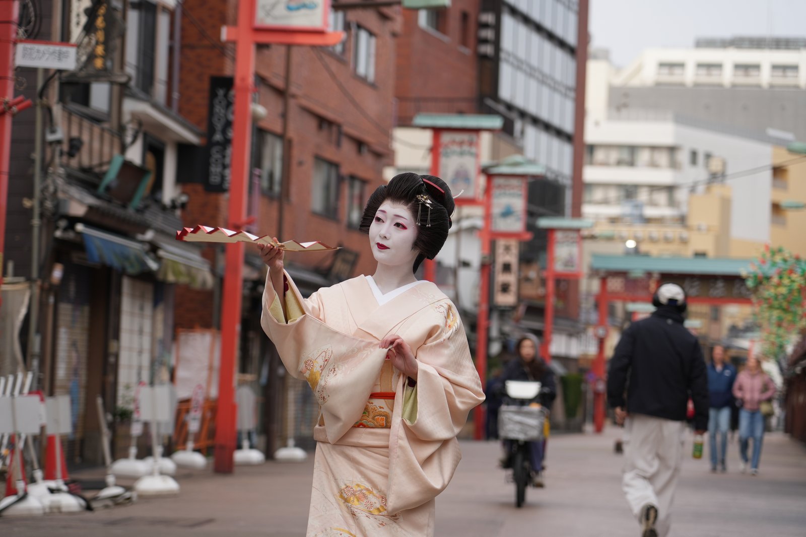 An Asakusa geisha dancing outdoors on a neighbourhood street, one of the ways to encounter geisha in Tokyo without a reservation