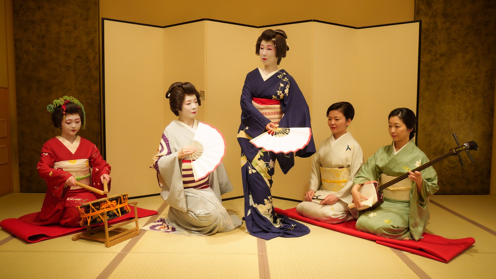 Tachikata geisha dancing while jikata geisha plays shamisen in the same tatami room during an ozashiki