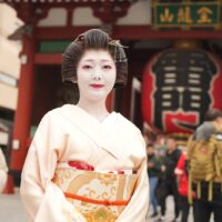 An Asakusa geisha in kimono walking a lantern-lined street in Asakusa, Tokyo