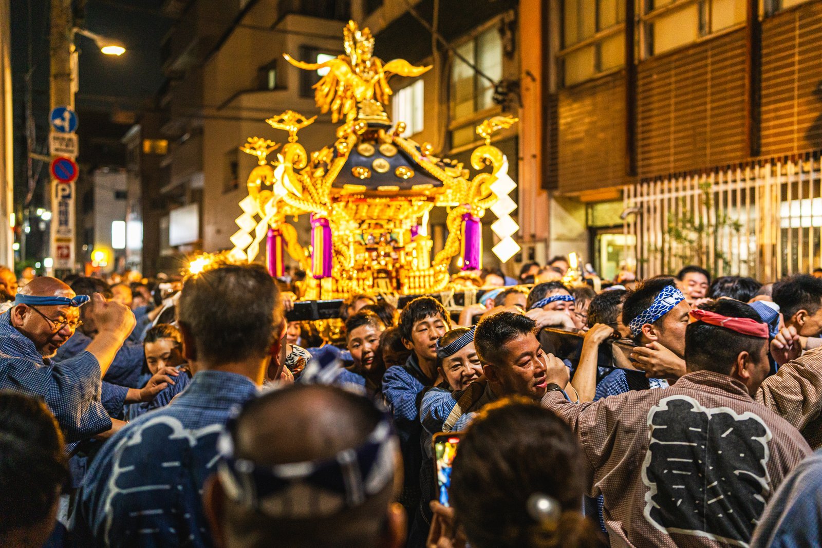 Neighborhood mikoshi teams in matching happi coats carrying their portable shrines toward Senso-ji on the Saturday of Sanja Matsuri