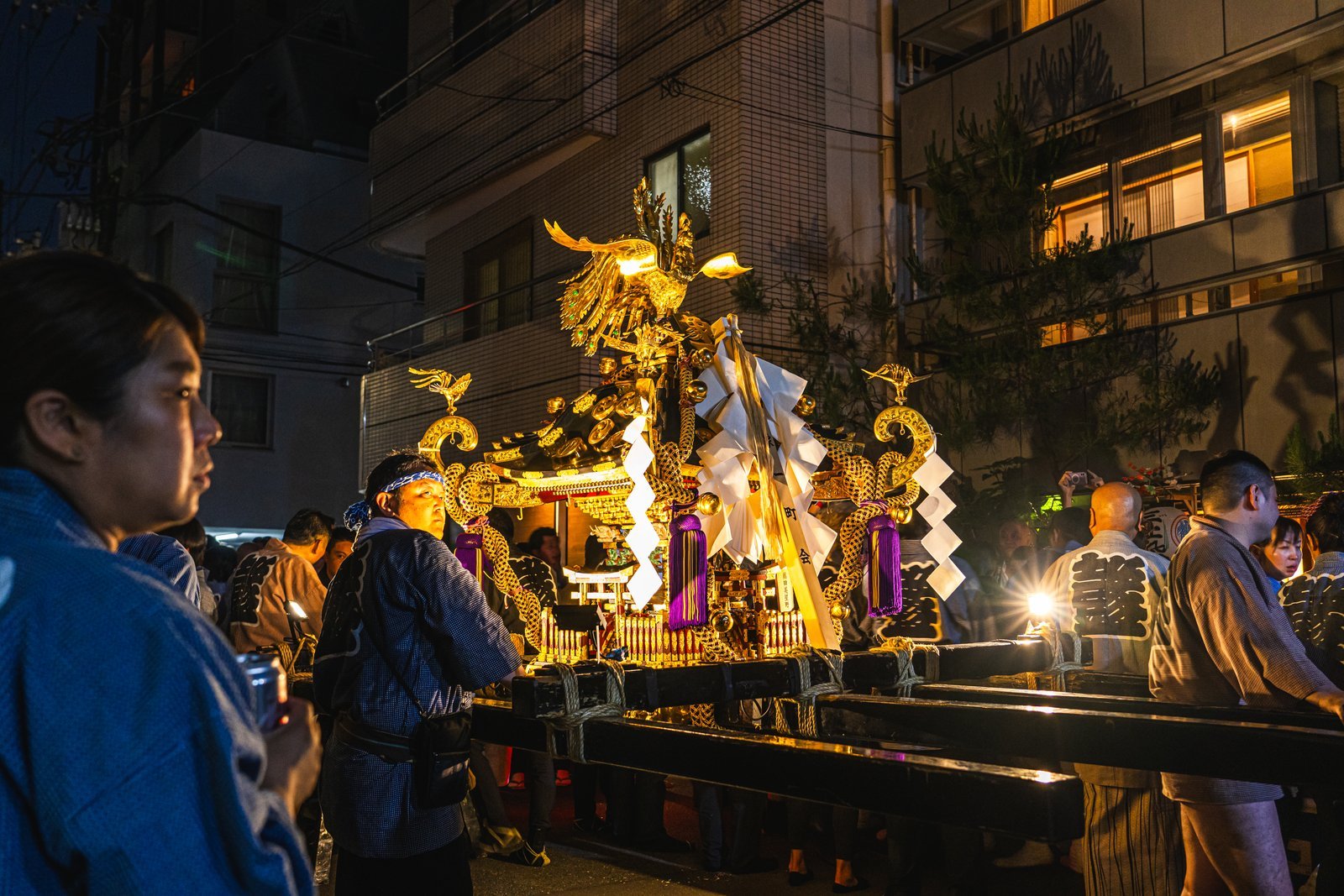Bearers packed shoulder to shoulder beneath a mikoshi carrying pole during Sanja Matsuri in Asakusa