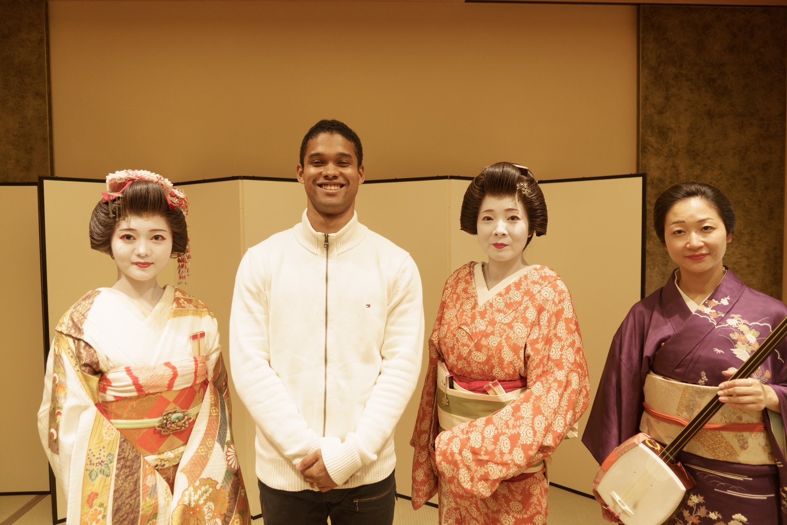 Geisha, a hangyoku, a jikata musician and a guest gathered for a photo at the end of an ozashiki evening at Miyakodori
