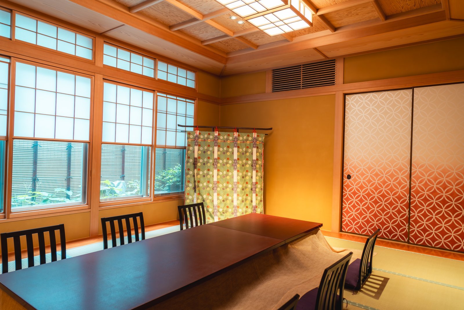 The private tatami room at Miyakodori set with low chairs at the table and a seasonal arrangement