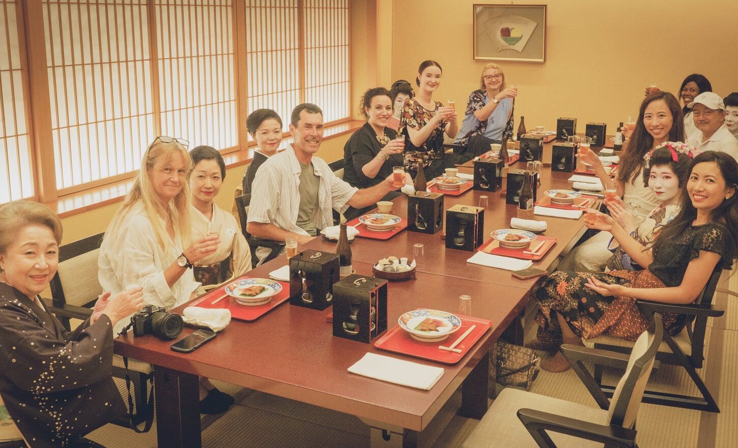 Guests raising a toast with an Asakusa geisha and the okami during a private ozashiki at Miyakodori