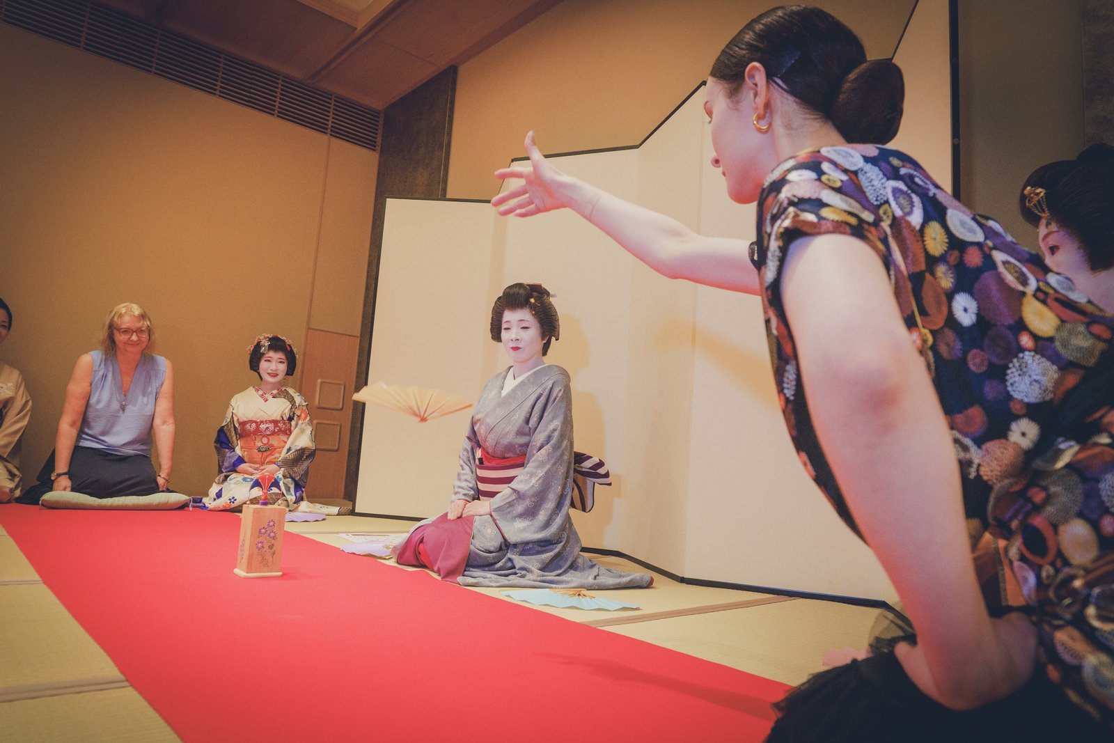 A guest's tosenkyo fan flying toward the cho target during a private ozashiki at Miyakodori