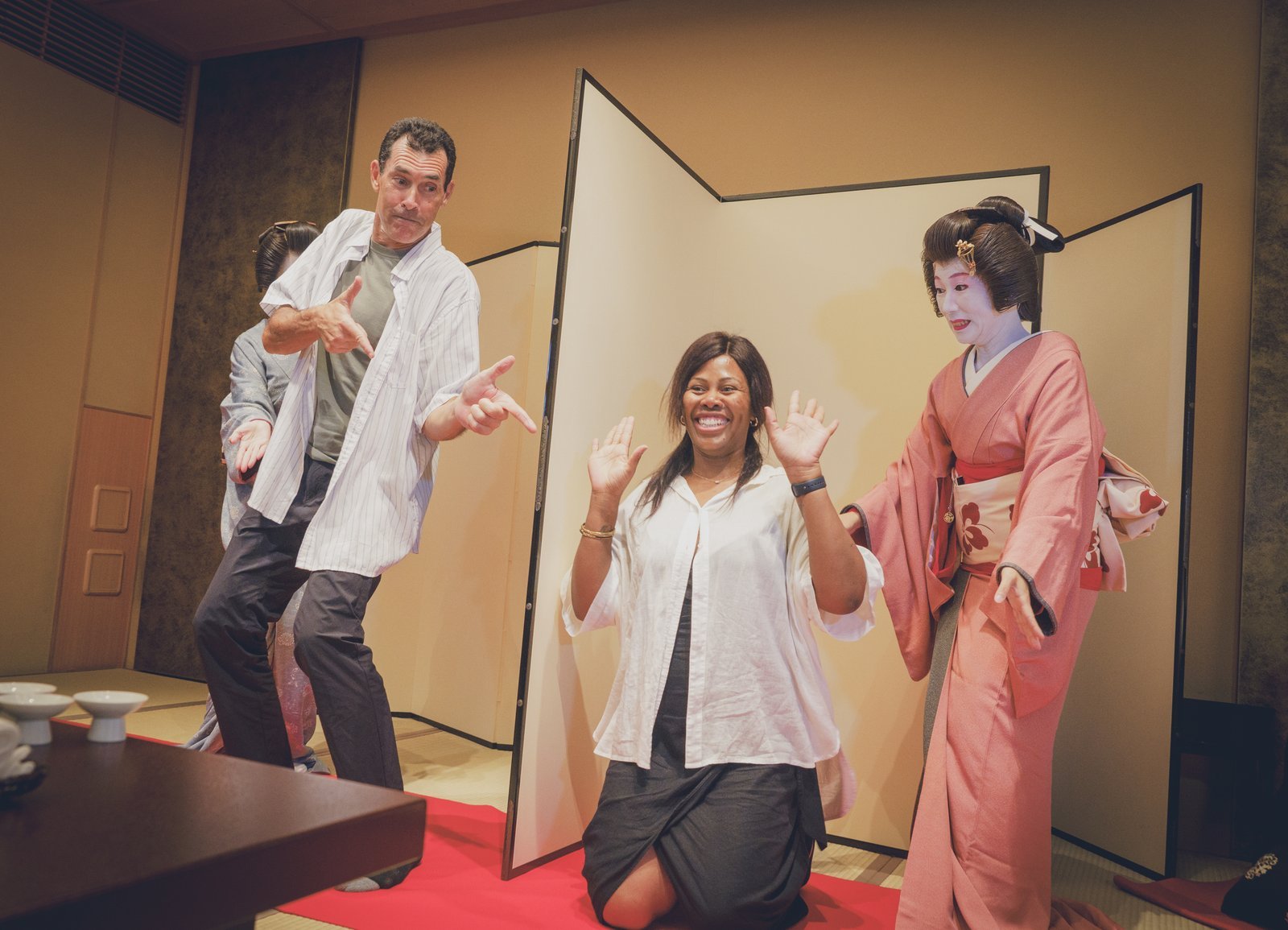 Two players striking the tiger and hunter poses on either side of a folding screen during Tora Tora