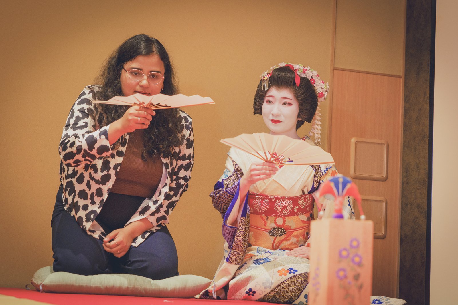 A guest taking aim with a folding fan at the butterfly target during a game of Tosenkyo at Miyakodori