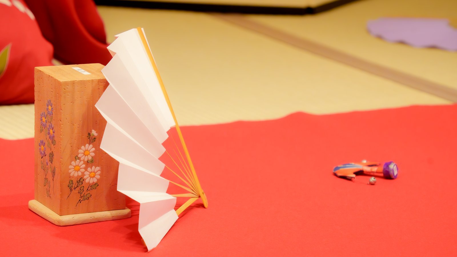 The tosenkyo set laid out on tatami: the makura stand, the butterfly target and a folding fan
