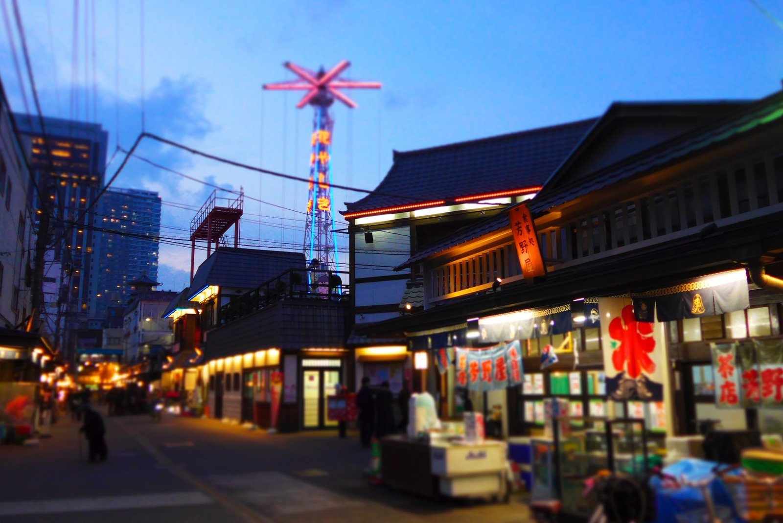 Quiet Asakusa back street west of Senso-ji at dusk, lined with small bars and low wooden buildings