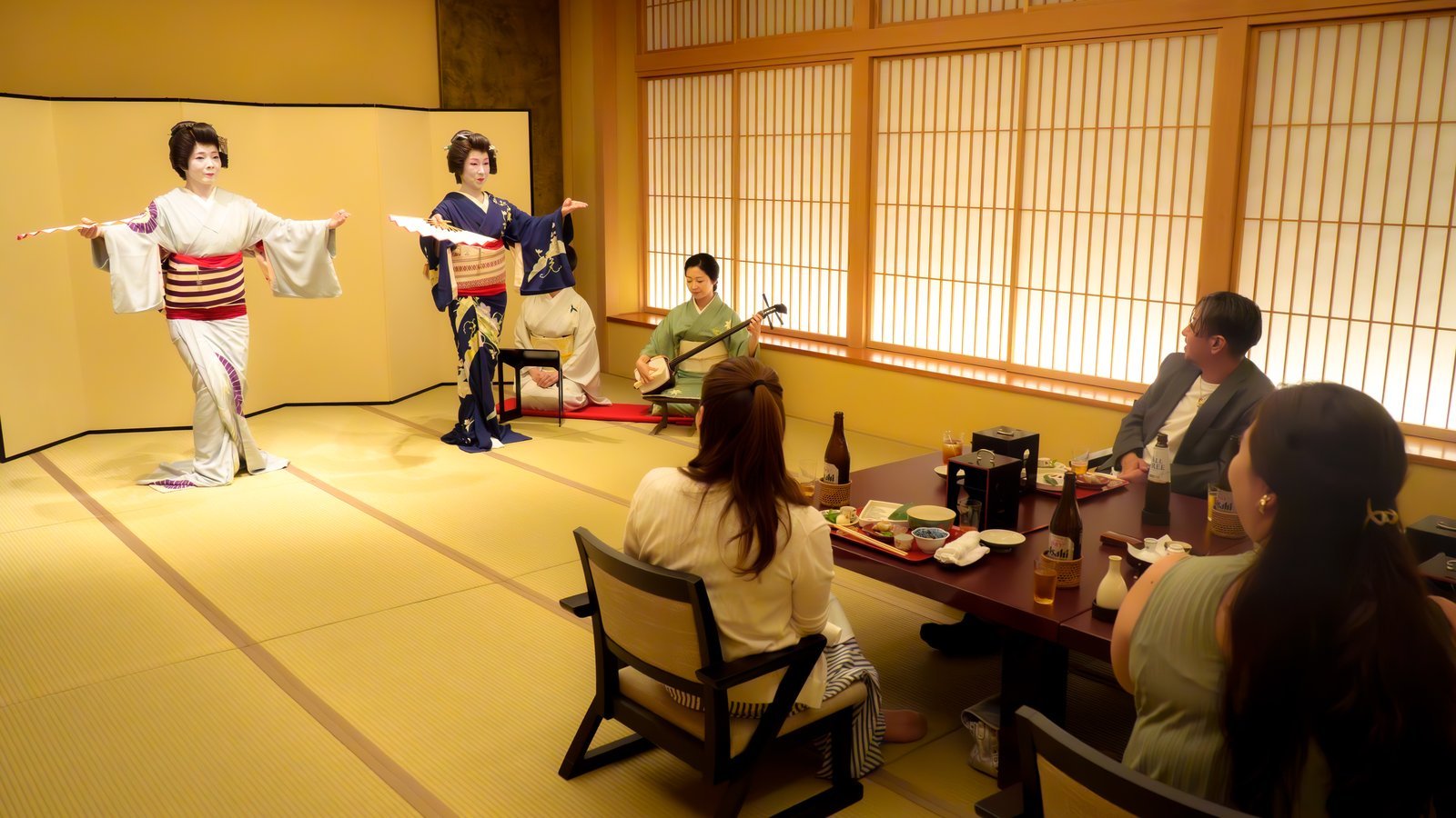 Asakusa geisha performing a dance to shamisen music inside a private tatami room at a traditional teahouse