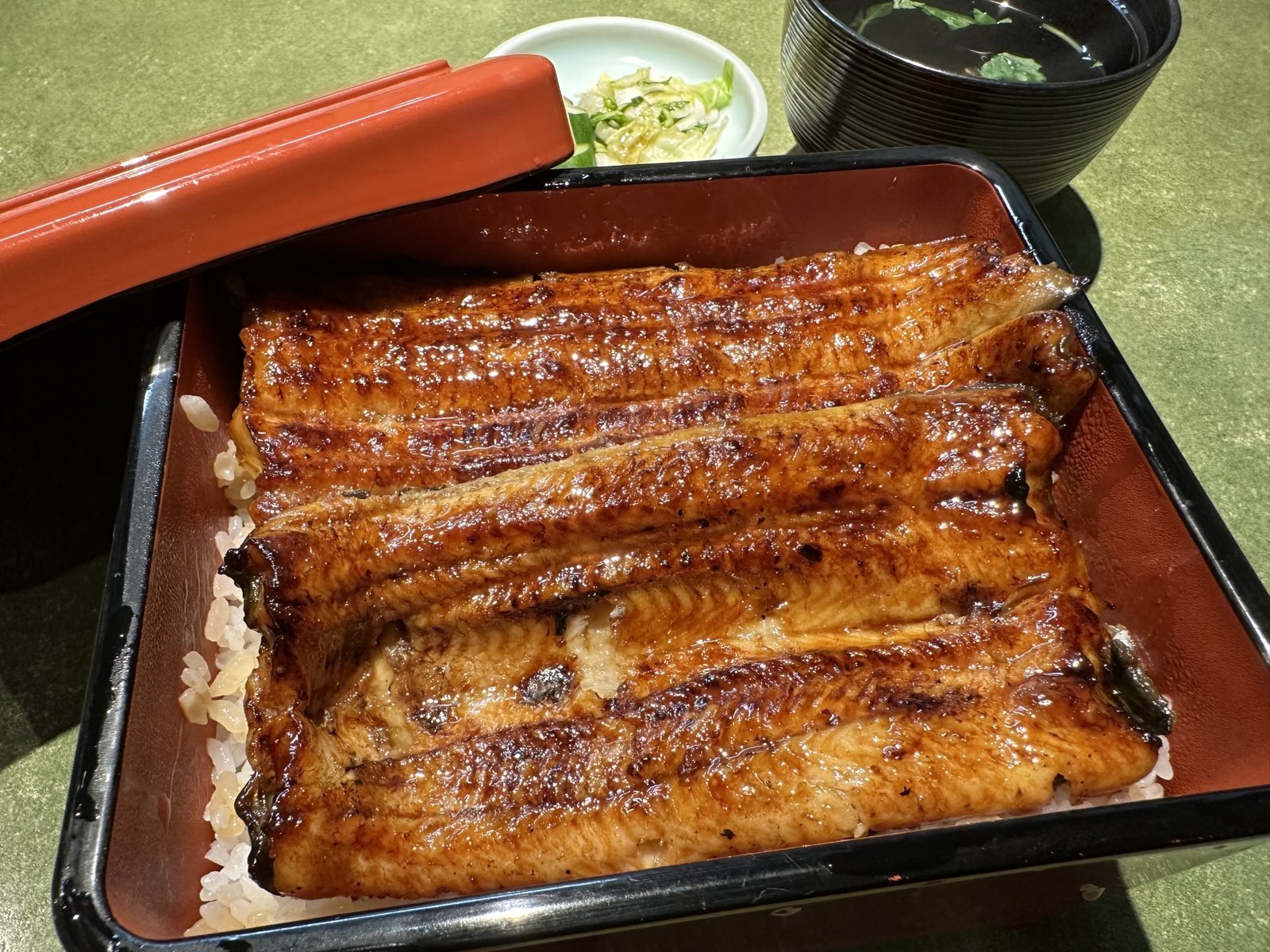 A grilled eel (unagi) rice box set with soup and pickled condiments