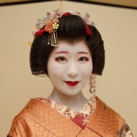 An Asakusa hangyoku in white makeup with the momoware hairstyle and kanzashi ornaments