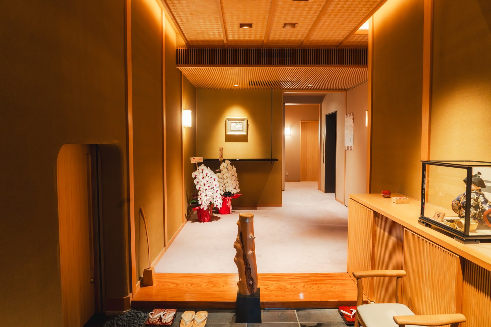 The entrance hall of an Asakusa machiai-chaya, sandals set out on the stone floor below the raised wooden step