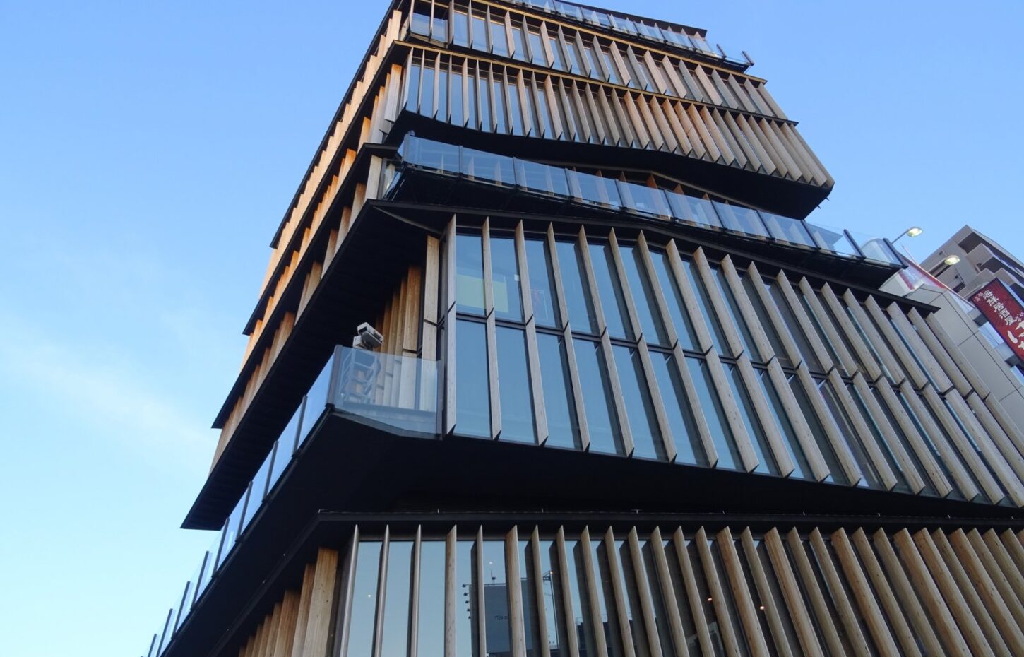 The Asakusa Culture Tourist Information Center, a stacked wooden building, under a blue sky