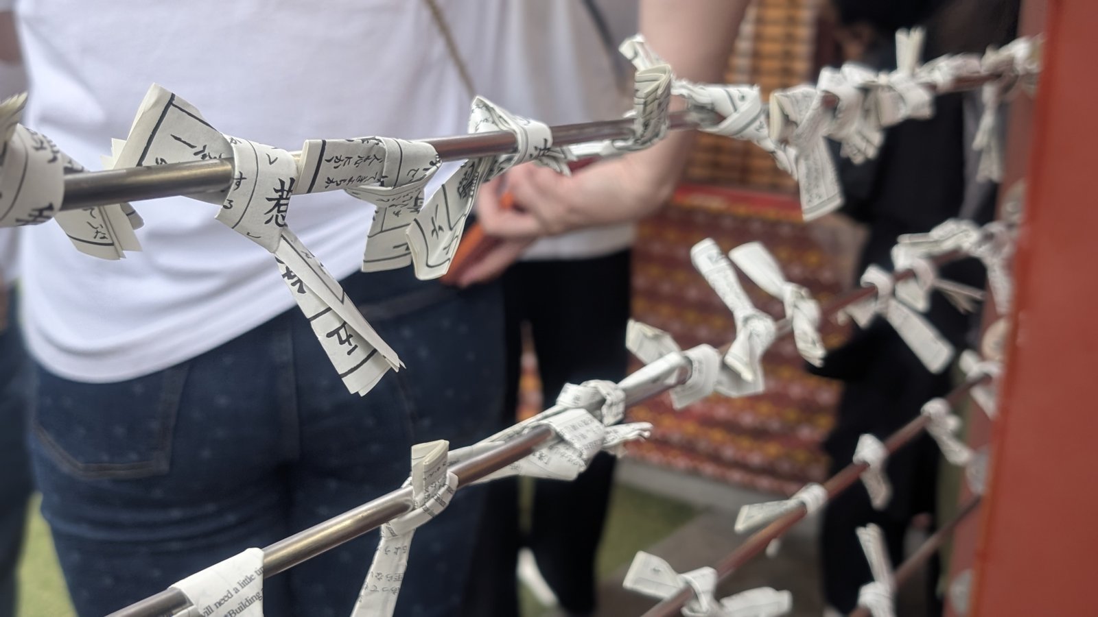 Omikuji fortune slips tied to a rack at a temple in Asakusa